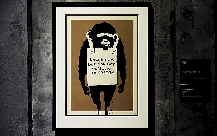 ‘Laugh now’ incluye a uno de los famosos monos del artista británico. 