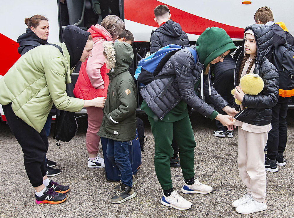 Dos imágenes tras la llegada ayer a Palencia de los jóvenes y familias procedentes de Ucrania. 