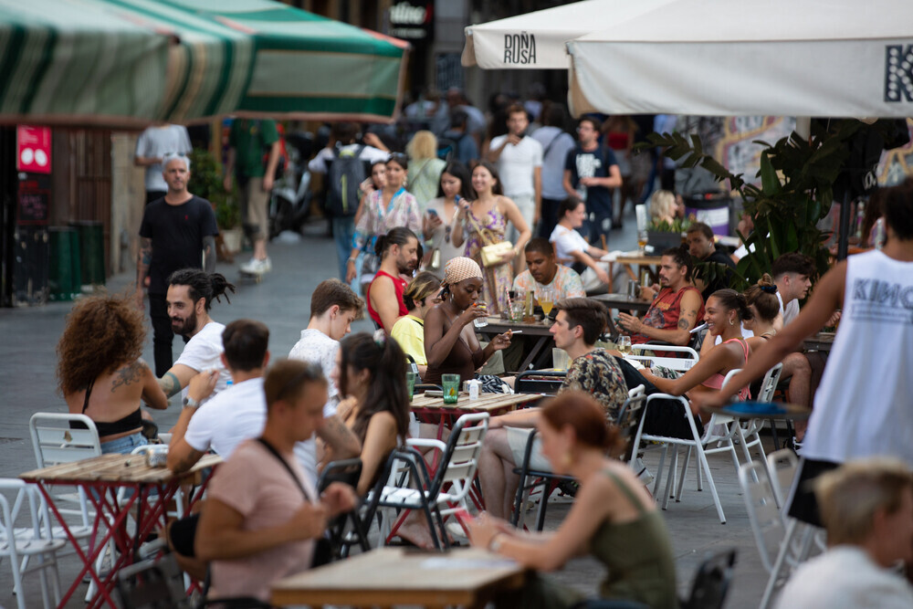 Varias personas sentadas en bares en la plaza dels Àngels del Raval, en Barcelona, Cataluña.
